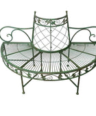 Decorative green metal bench on a wooden floor with a white wall background