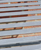 Close-up of a metal slatted surface with a blurred background