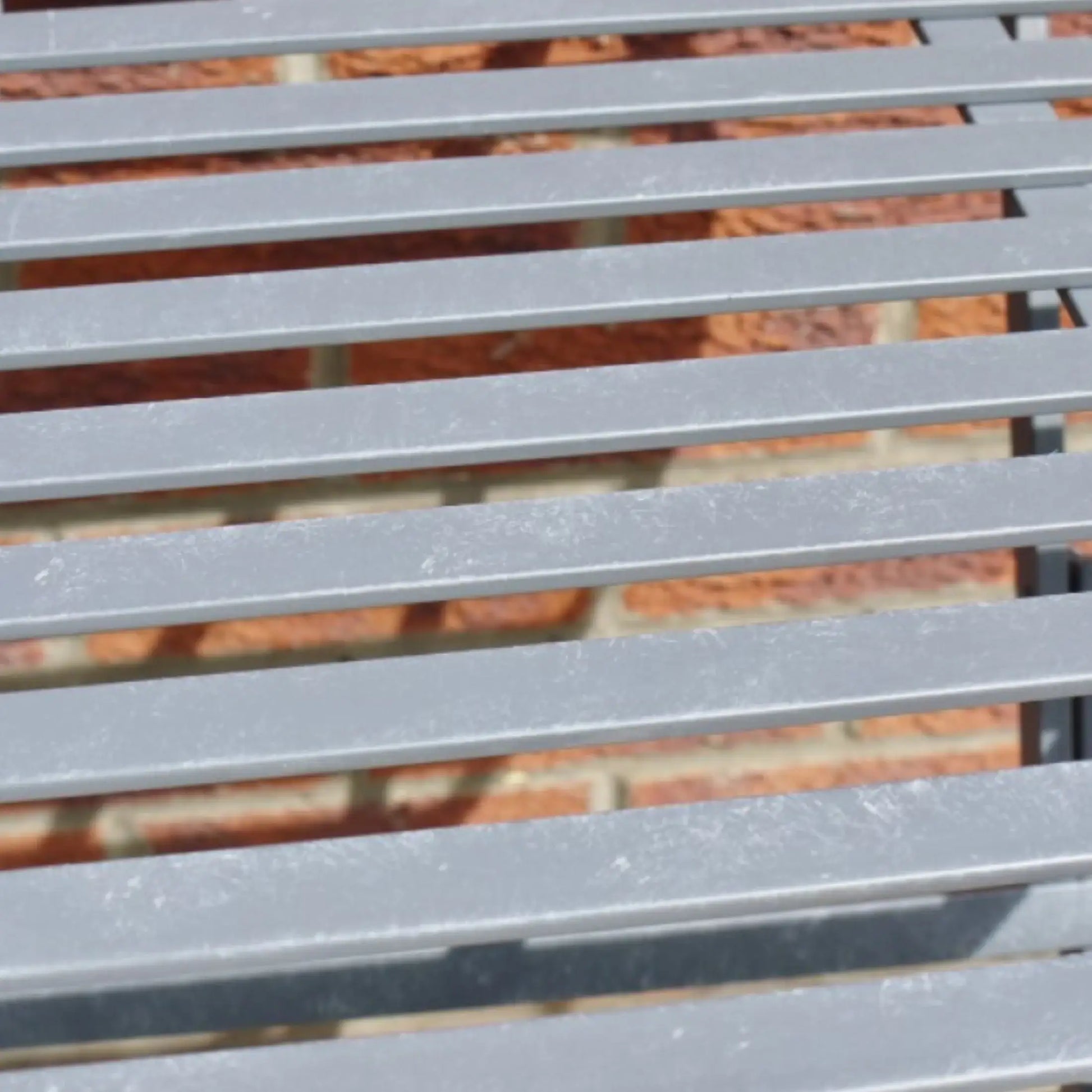 Close-up of a metal slatted surface with a blurred background