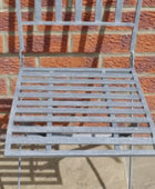 Metal chair against a brick wall