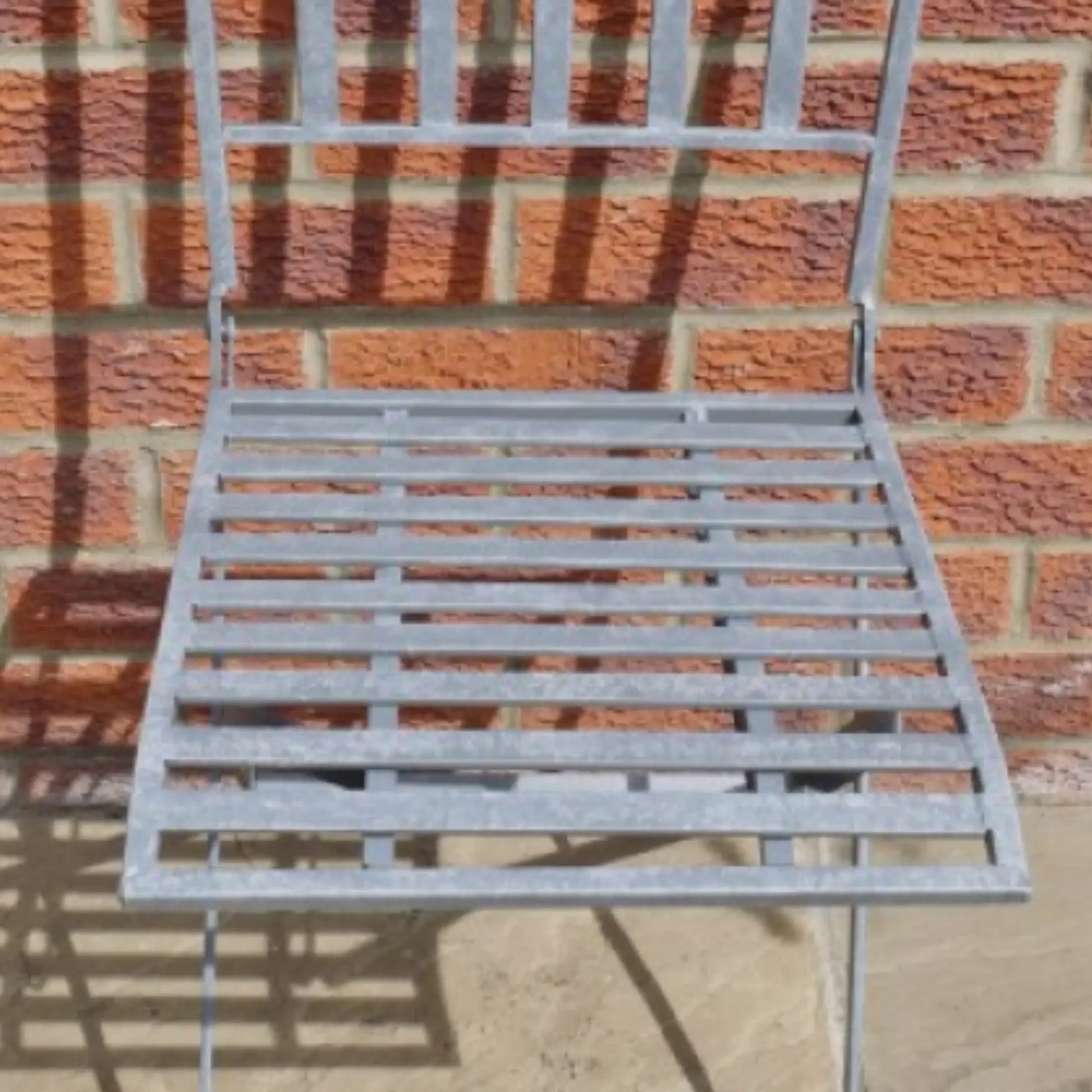 Metal chair against a brick wall