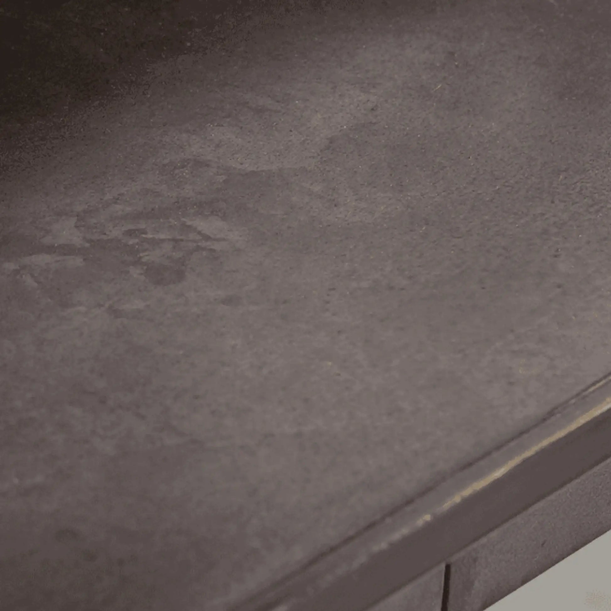 Close-up of a textured dark gray surface with a metallic edge.