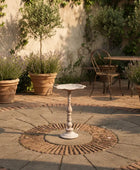 Outdoor patio with a small table, chairs, and potted plants.