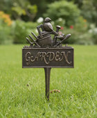 Garden-themed decorative sign with a bird and tools on a grassy background