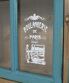 Vintage-style window with 'Boulangerie de Paris' sign on a blue frame.