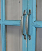 Close-up of a blue cabinet with metal handles on a blurred background