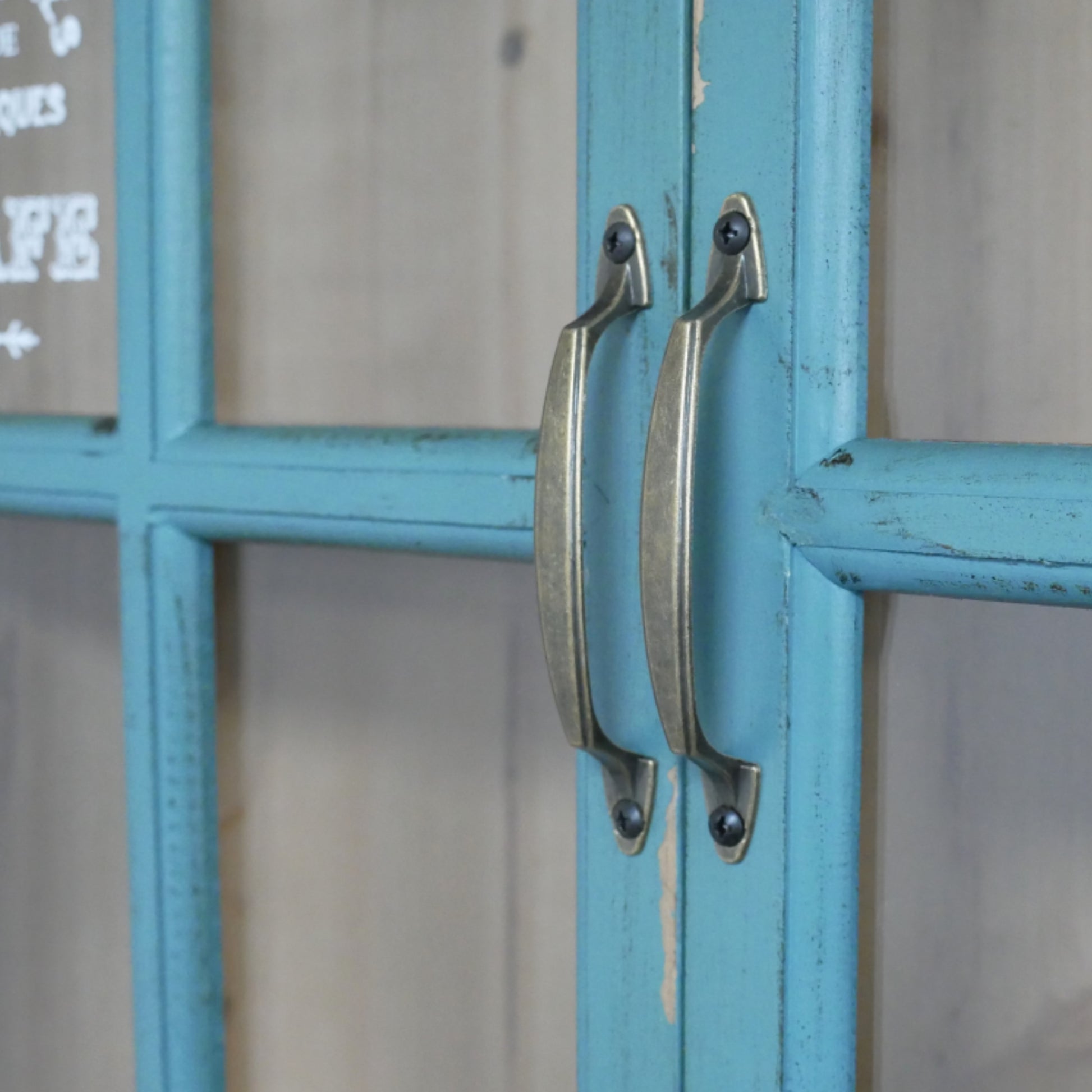 Close-up of a blue cabinet with metal handles on a blurred background