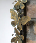 Decorative metal butterflies on a fireplace mantle.