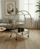 Round metal bar cart in a room with wooden floor, rug, and window.