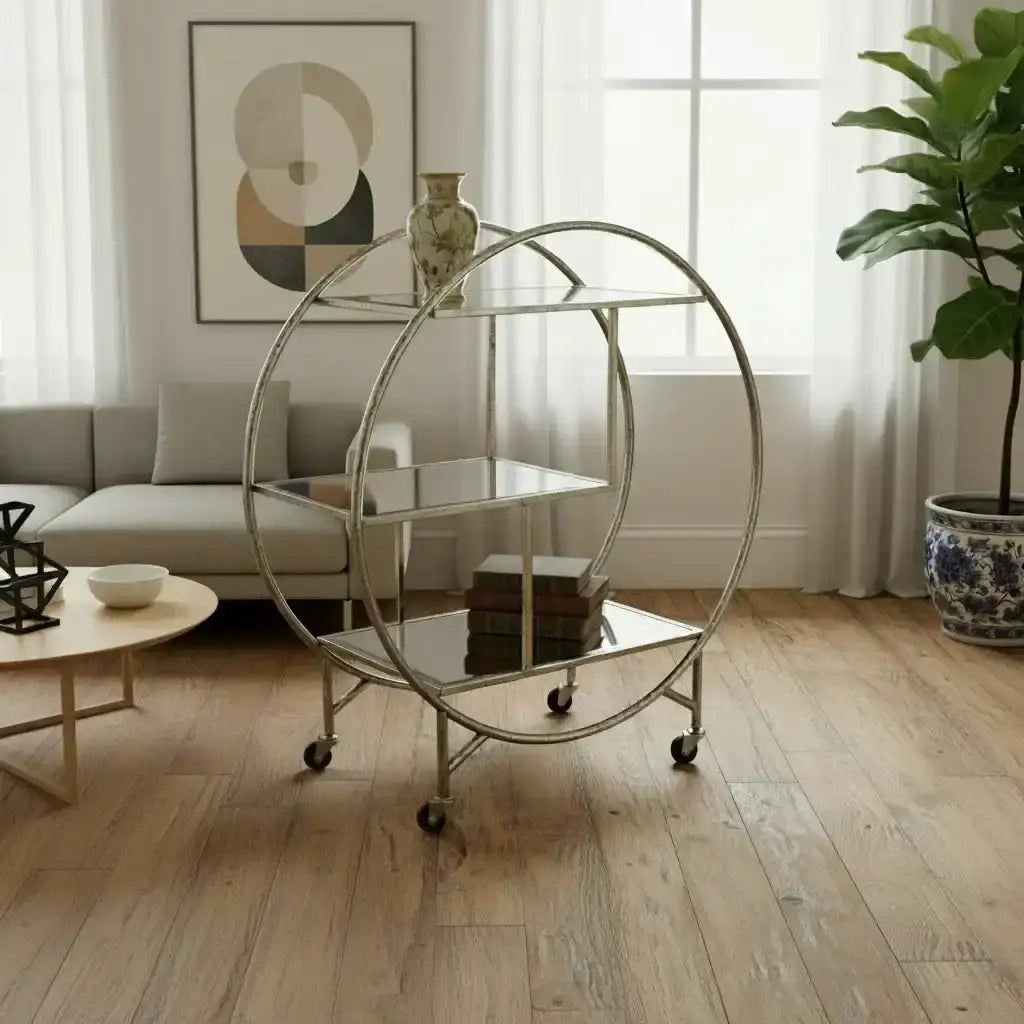 Round metal bar cart in a room with wooden floor, rug, and window.