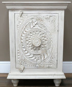 Decorative white cabinet with intricate carvings on a plain background