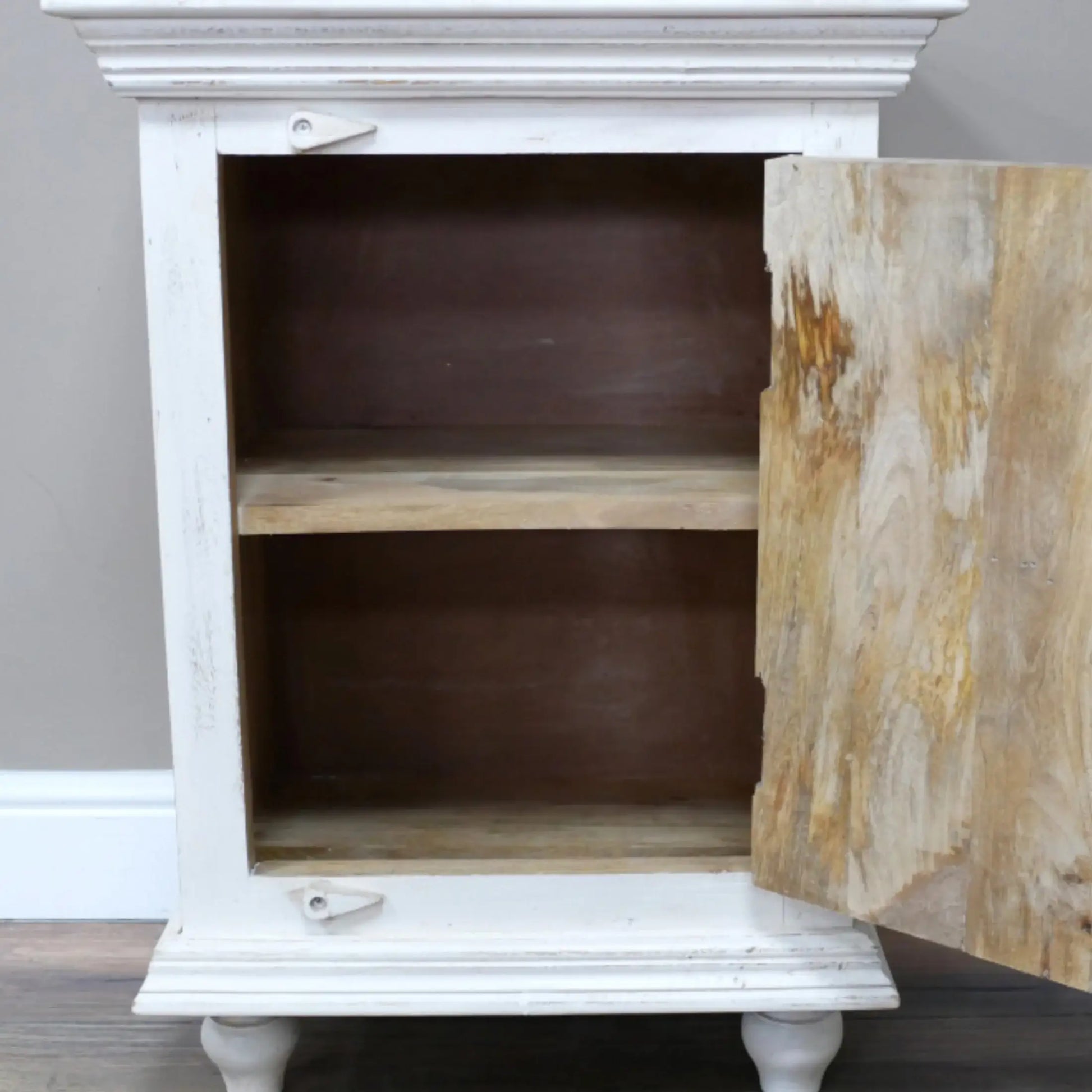 White cabinet with a wooden door open, on a gray floor.