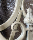Close-up of decorative metal hook with intricate design against a textured background