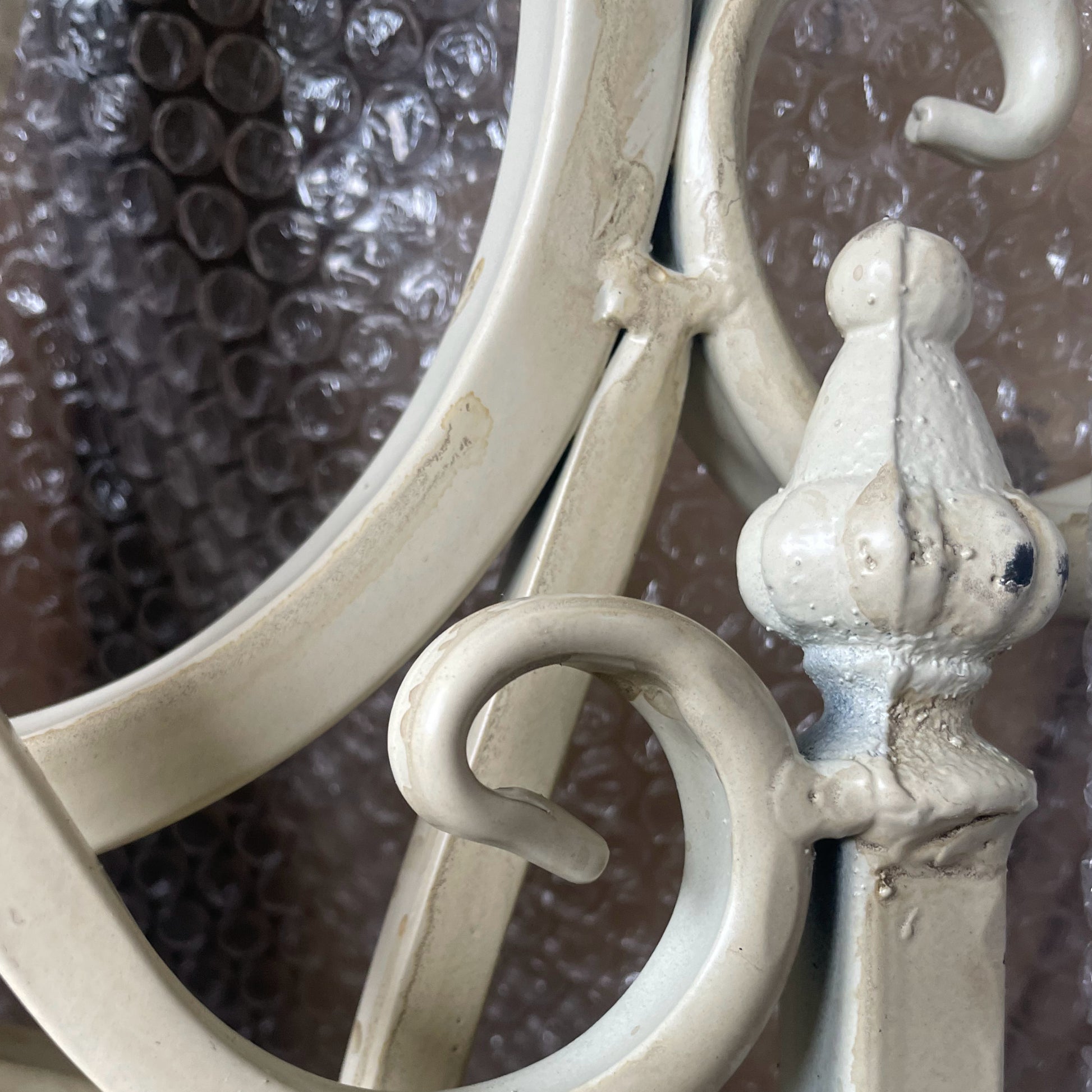 Close-up of decorative metal hook with intricate design against a textured background