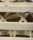 Close-up of a white metal lattice structure with visible wear and rust.