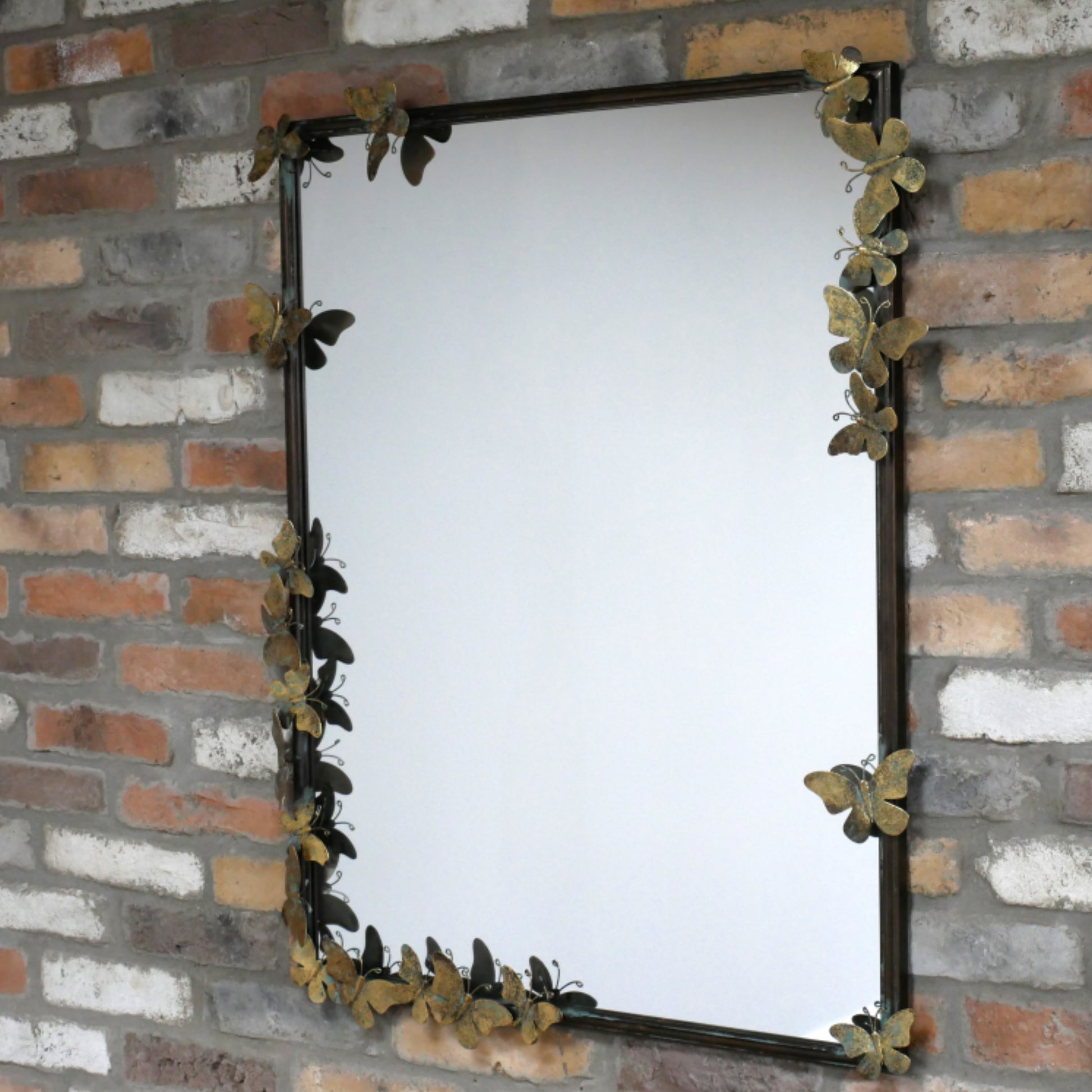 Decorative mirror with butterfly design on a brick wall
