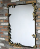 Decorative mirror with butterfly design on a brick wall