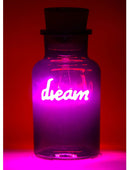 A clear glass bottle with a dark stopper, glowing with a bright pink and purple neon light that spells out the word 'dream' in white script, set against a dark red background.