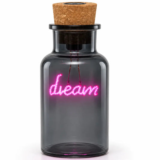 A small dark glass bottle with a cork stopper, featuring a glowing pink neon-style 'dream' sign on the front, shown against a plain white background.