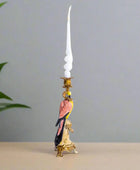 Decorative candle holder with a parrot design on a plain background