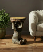 Wooden side table with natural finish next to a potted plant and a fluffy chair in a room.