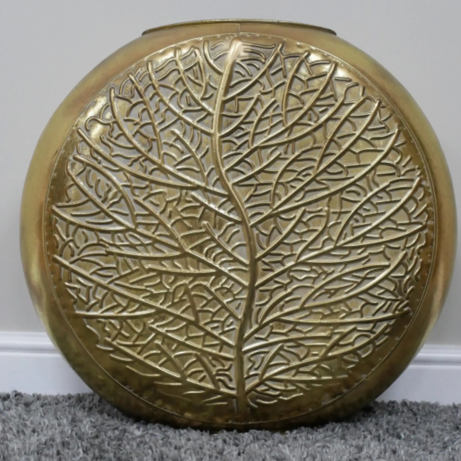 Decorative round object with leaf pattern on a plain background