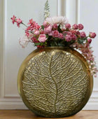Decorative gold vase with floral arrangement on a gray surface