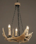 Chandelier with antler design and four light bulbs on a plain background