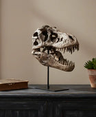 Dinosaur skull on a stand with a book and plant in the background