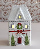 Decorative house-shaped lantern with Christmas design on a neutral background
