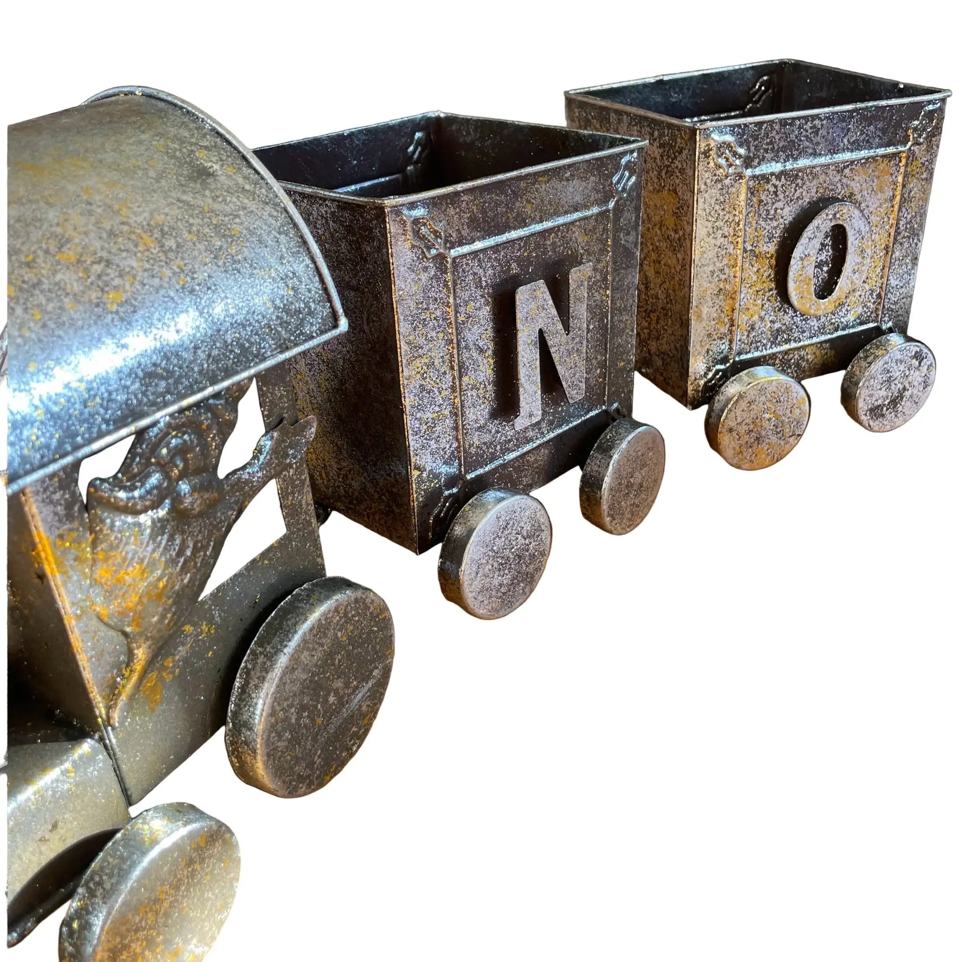 Three rustic metal train car planters with letters on a wooden floor.