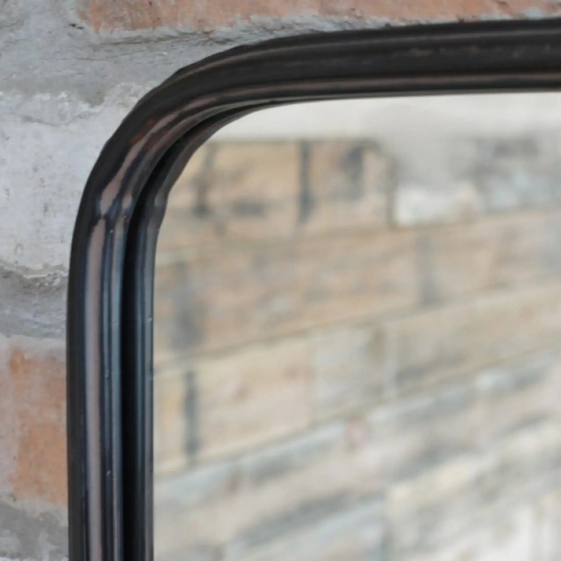 Rectangular mirror with black frame on a textured wall