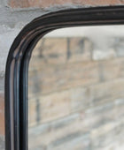 Rectangular mirror with black frame on a textured wall