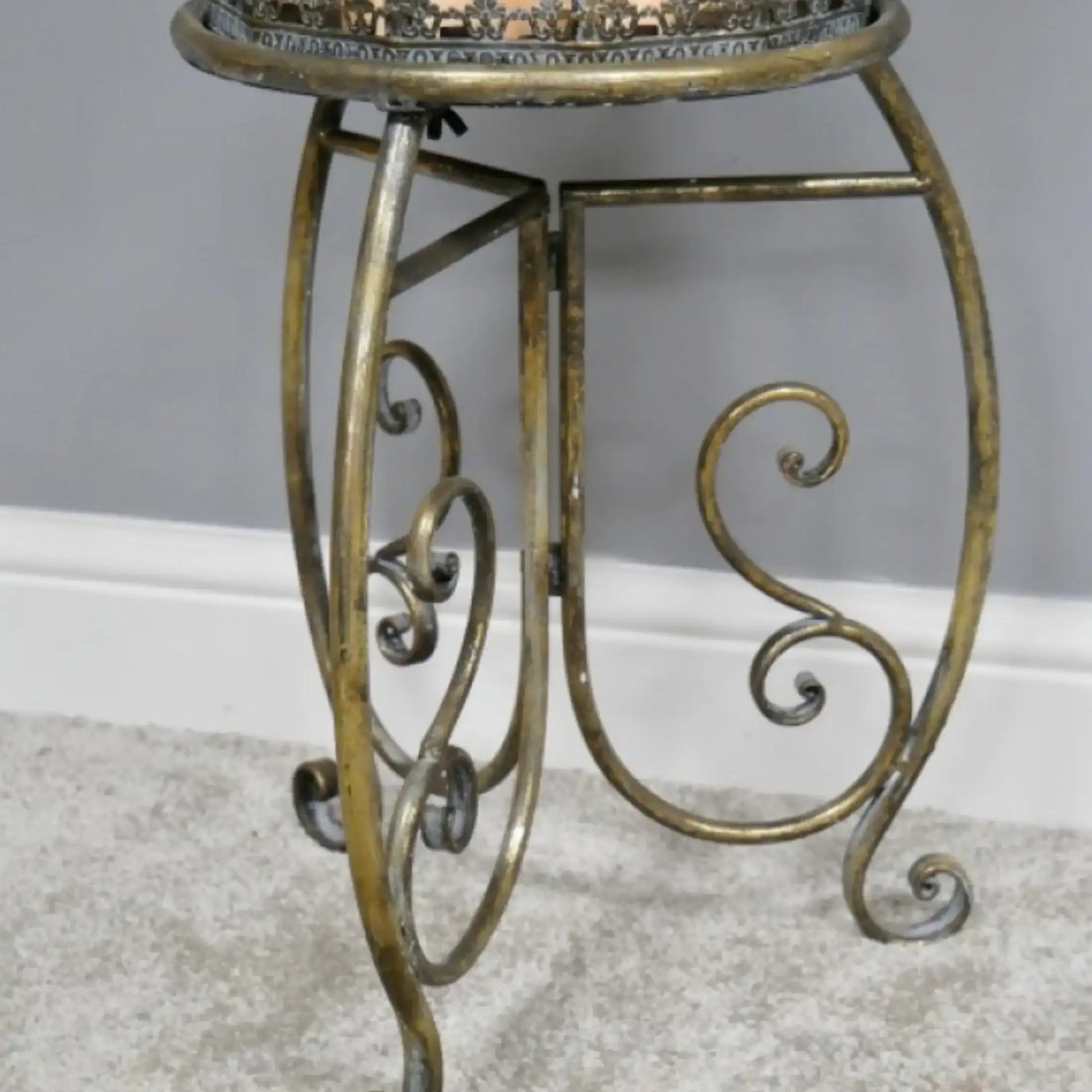 Decorative metal table with intricate designs on a neutral background