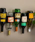 Recycled wine bottles with vintage labels arranged on a wall.