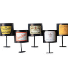 Five cylindrical candles with vintage label designs on a white background