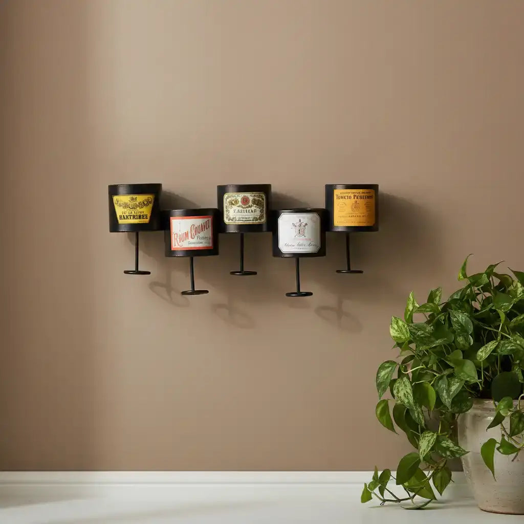 Wall-mounted candle holders with vintage-style labels against a beige wall, accompanied by a potted plant.