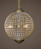 Decorative spherical hanging light fixture with crystal details on a brown background