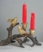 Decorative candle holder with birds and red candles on a white background