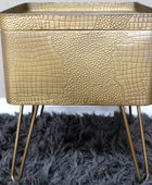 Gold textured side table with hairpin legs on a dark gray rug