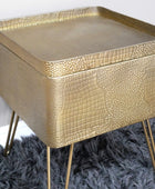 Gold textured side table on a gray rug