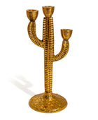 Gold cactus-shaped candle holder on a white background