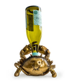 Gold crab-shaped bottle holder with a wine bottle on a white background