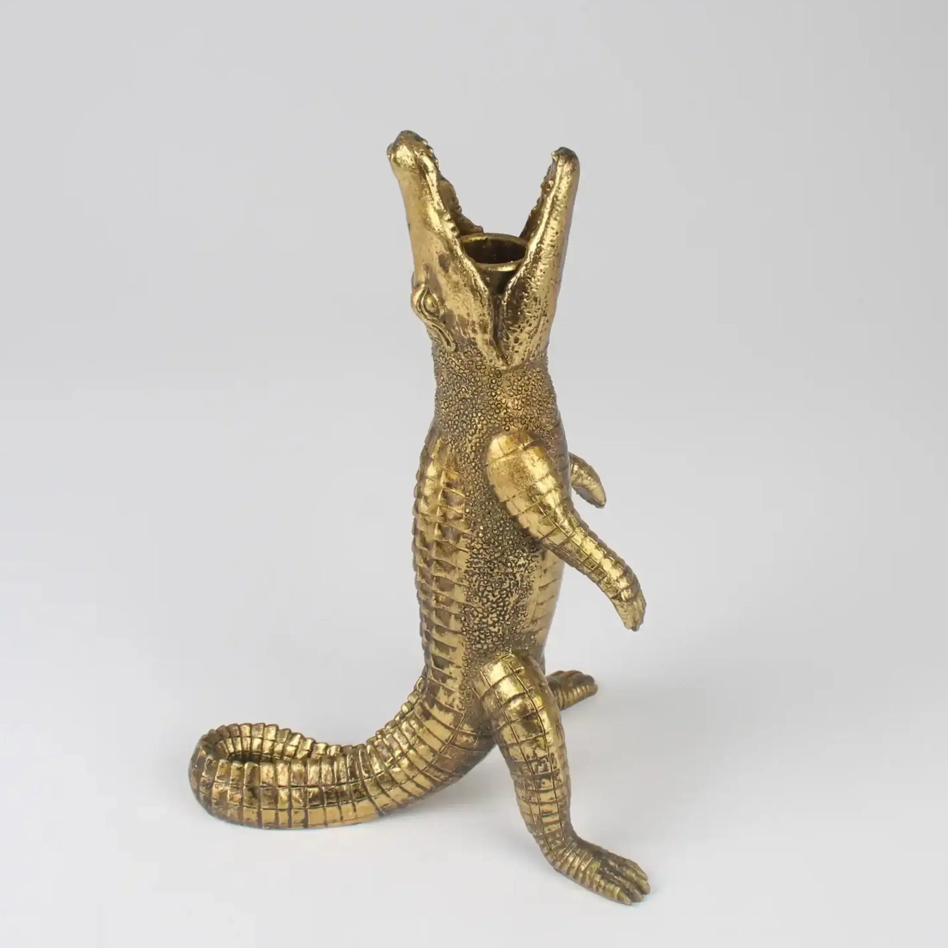 Gold alligator-shaped pen holder on a white background