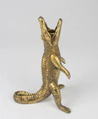 Gold alligator-shaped pen holder on a white background
