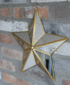Gold star-shaped mirror hanging on a brick wall