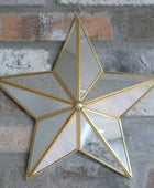 Star-shaped mirror with gold frame on a brick wall