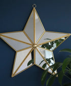 Star-shaped mirror with gold frame on a dark blue wall