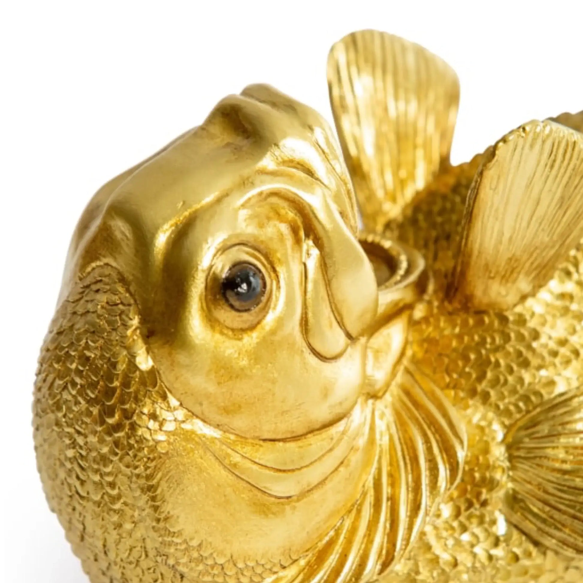 Gold fish figurine on a white background
