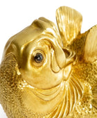 Gold fish figurine on a white background